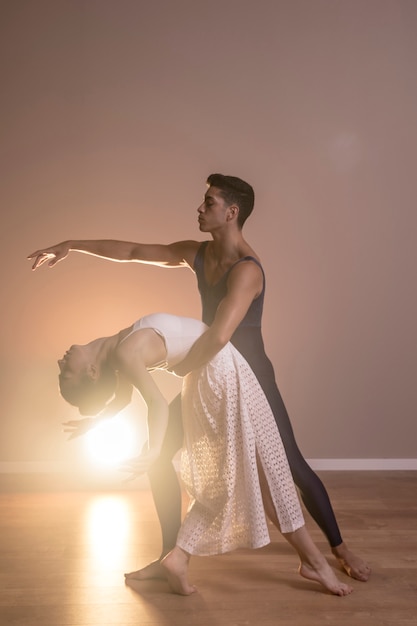 Full shot couple dancing together