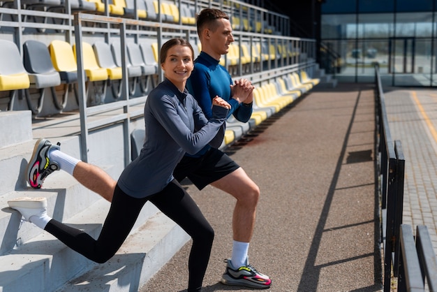 Full shot couple doing workout exercises