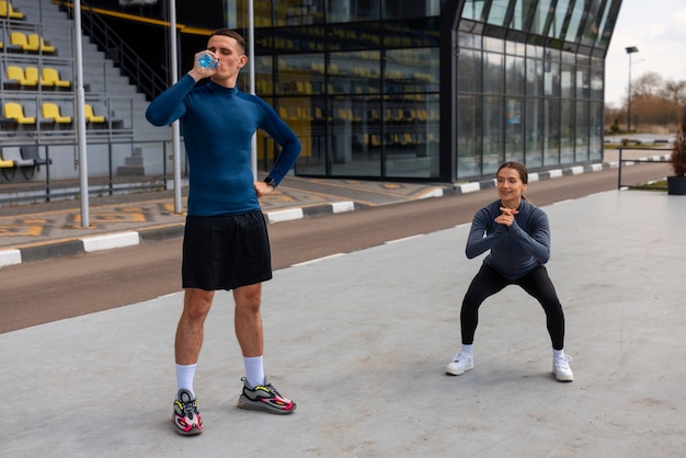 Full shot couple doing workout exercises