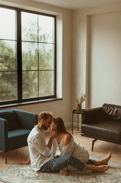 Full shot couple on floor kissing