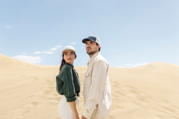Full shot couple holding hands in desert