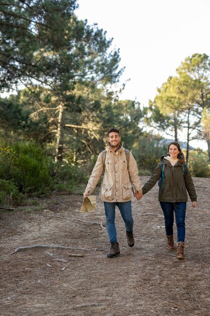 Full shot couple holding hands outdoors