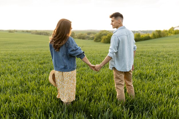 Full shot couple holding hands outside