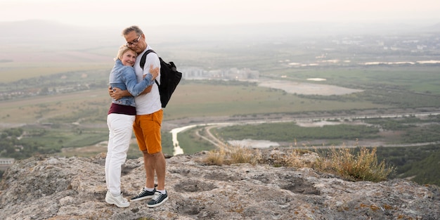 Full shot couple hugging on cliff