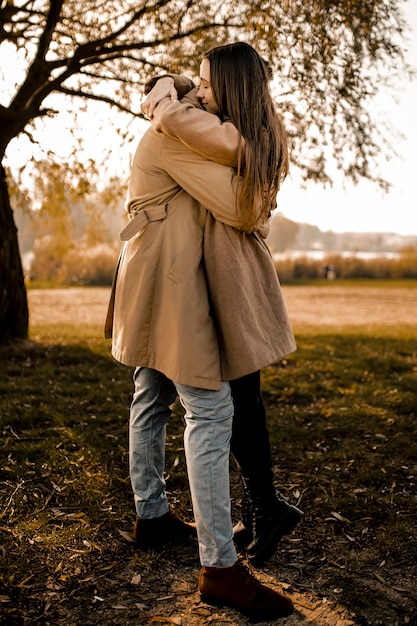 Full shot couple hugging outdoors