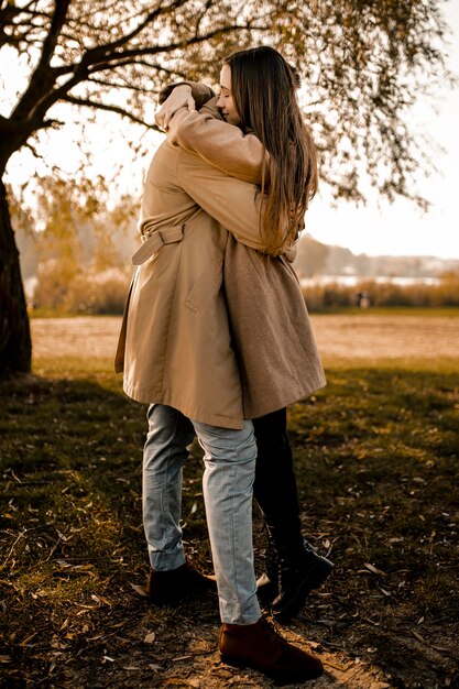 Full shot couple hugging outdoors