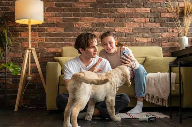 Foto gratuita coppie del colpo pieno al chiuso con il cane