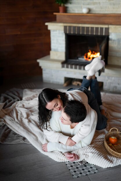 Full shot couple laying by the fireplace