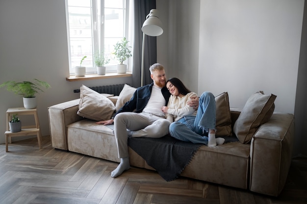 Full shot couple laying on couch