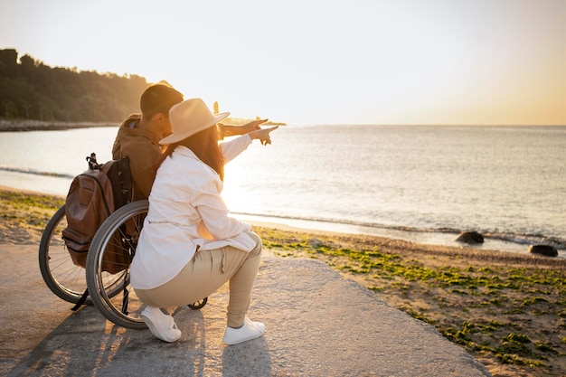 Free photo full shot couple looking at sea