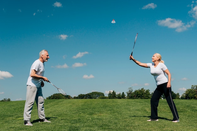 Free photo full shot couple playing tennis outdoors