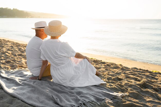 Full shot couple sitting on blanket