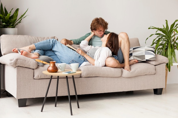 Full shot couple sitting on couch