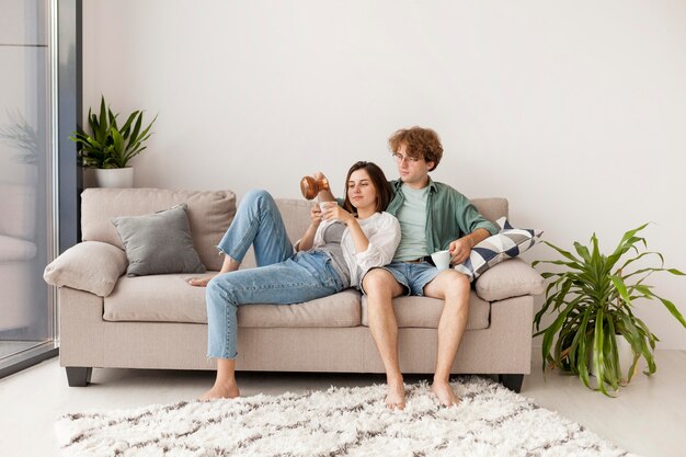 Full shot couple sitting on couch