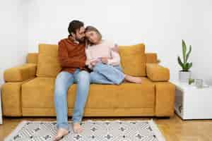 Free photo full shot couple sitting on couch