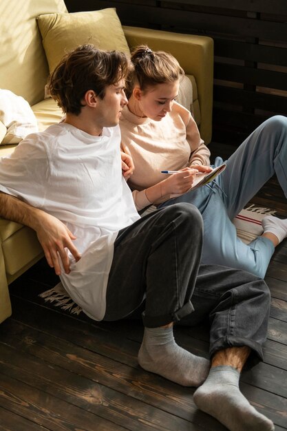 Full shot couple sitting on floor