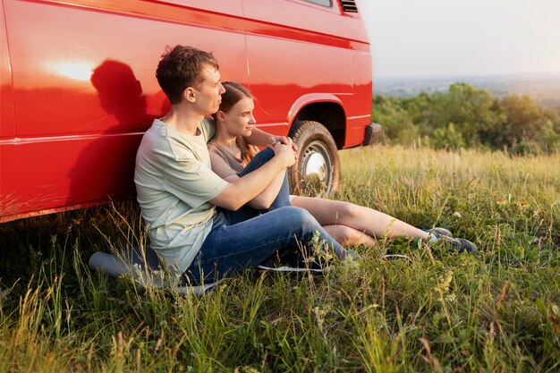 Full shot couple sitting on grass