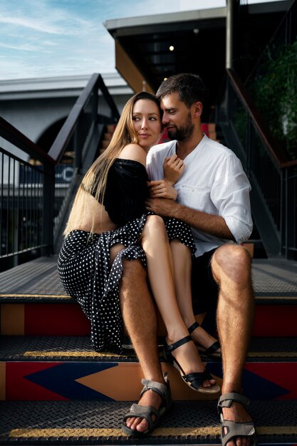 Full shot couple sitting on stairs