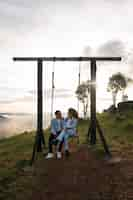 Free photo full shot couple on swing outdoors