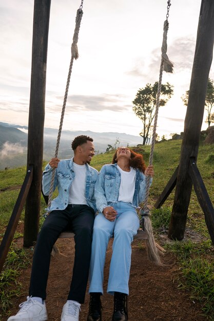 Full shot couple on swing outdoors