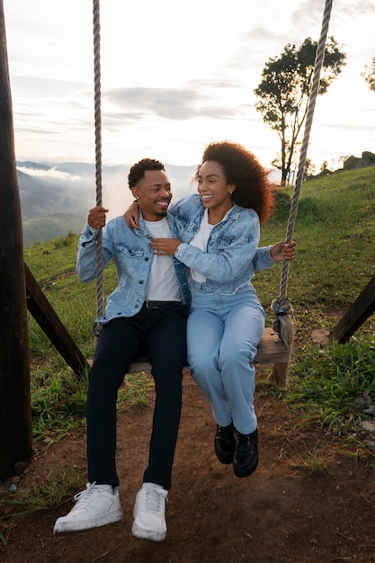 Full shot couple on swing outdoors