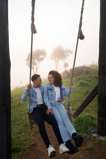 Full shot couple on swing outdoors