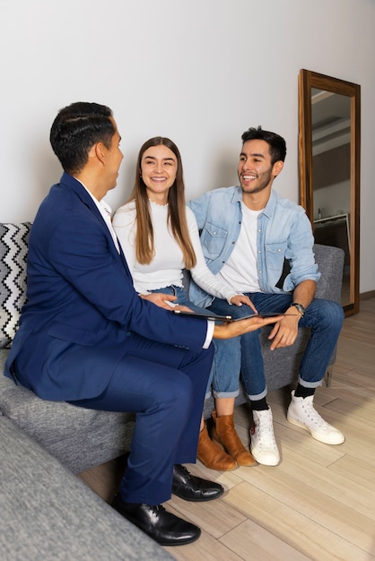 Free photo full shot couple talking to real estate agent