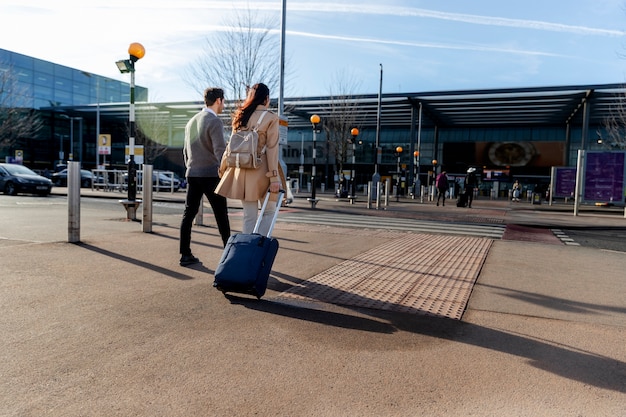 Full shot couple walking with baggage