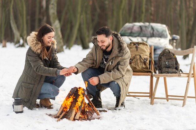 Full shot couple warming themselves