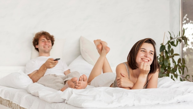 Full shot couple watching tv together