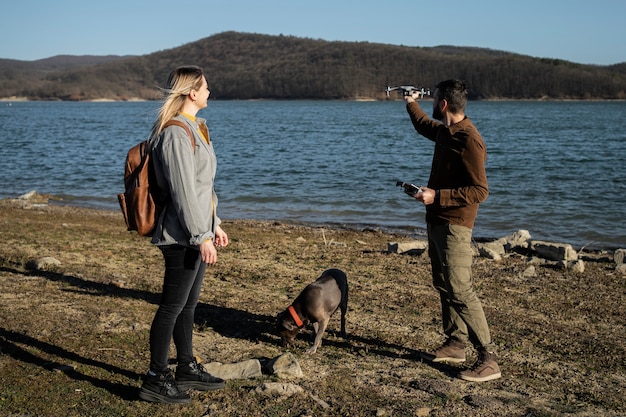 Full shot couple with drone outdoors