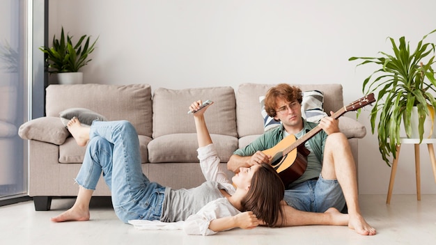 Full shot couple with guitar