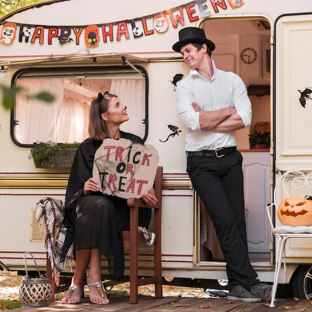 Full shot couple with trick or treat sign