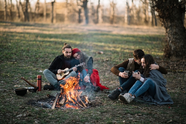 Full shot couples near campfire