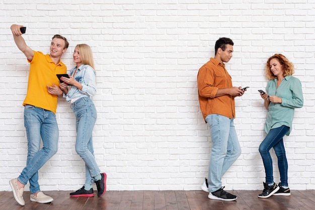 Full shot couples together with phones