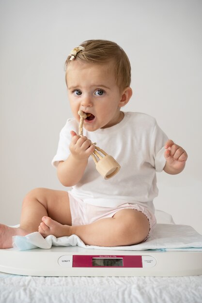 Full shot cute baby biting toy