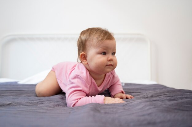 Full shot cute baby laying in bed