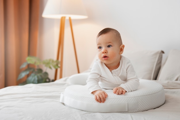 Full shot cute baby laying in bed