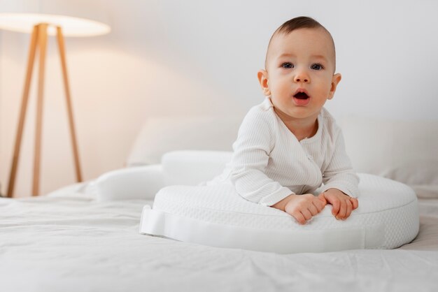 Full shot cute baby laying in bed