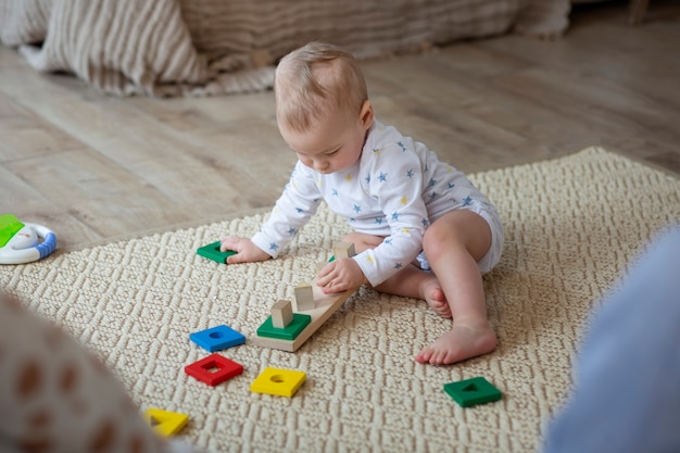 Foto gratuita bambino sveglio del colpo pieno che gioca sul pavimento