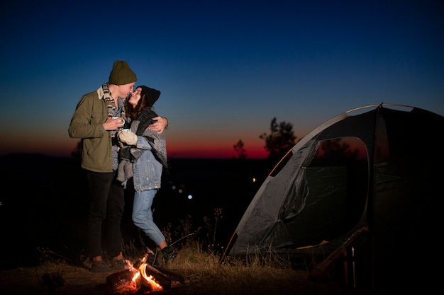 Full shot cute couple kissing in the nature