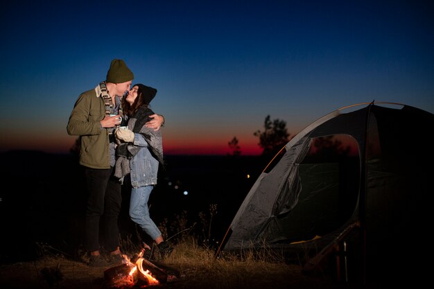 Full shot cute couple kissing in the nature