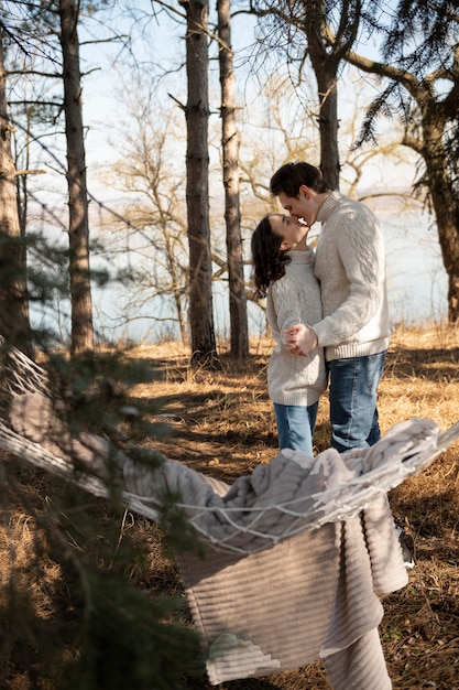 Free photo full shot cute couple kissing in nature