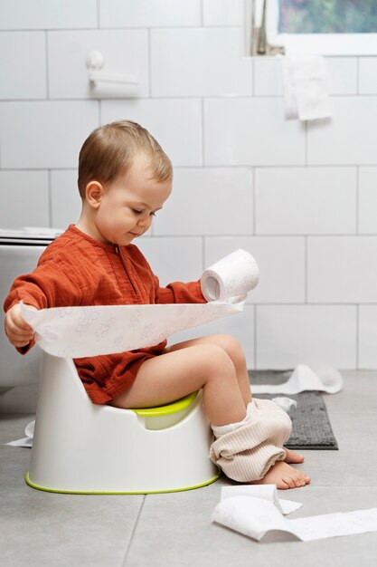 Full shot cute kid holding toilet paper