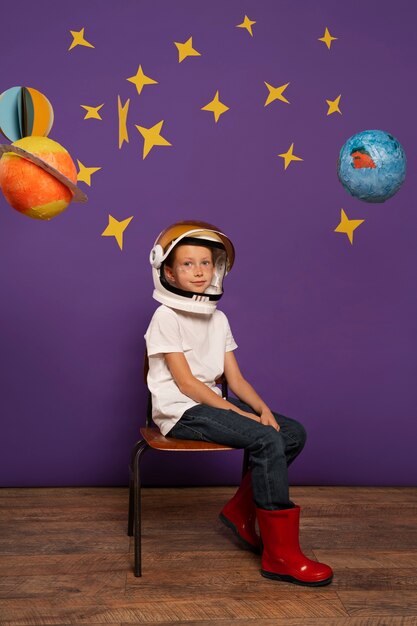 Free photo full shot cute kid sitting on chair