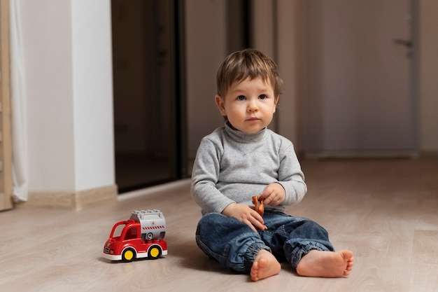 Free photo full shot cute kid sitting on floor