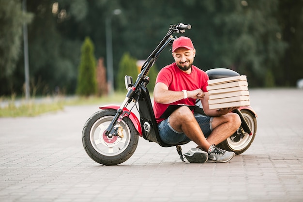 Foto gratuita ragazzo di consegna full shot guardando il suo orologio