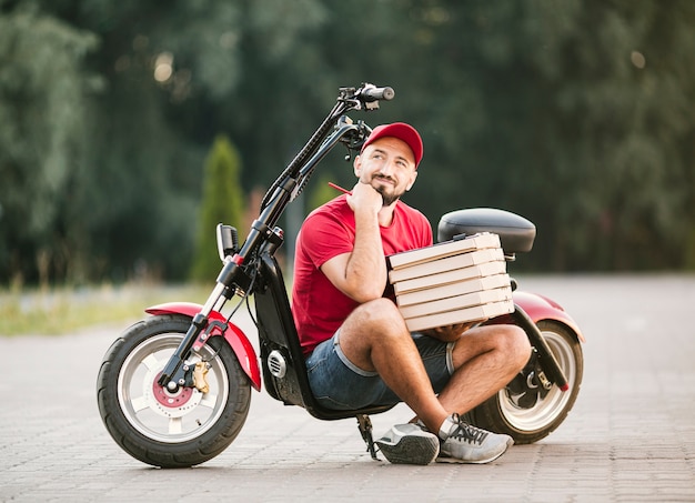 Foto gratuita pensiero del ragazzo di consegna della foto a figura intera