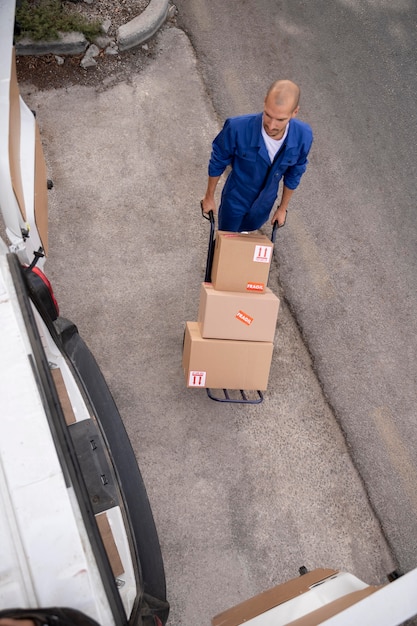 Full shot delivery man carrying boxes