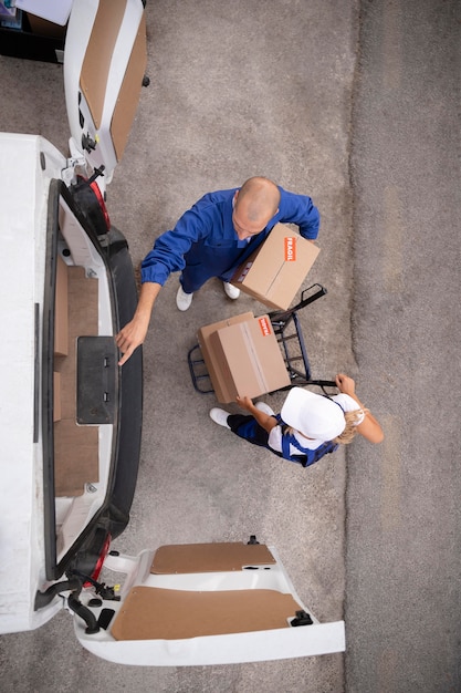 Free photo full shot delivery people holding box